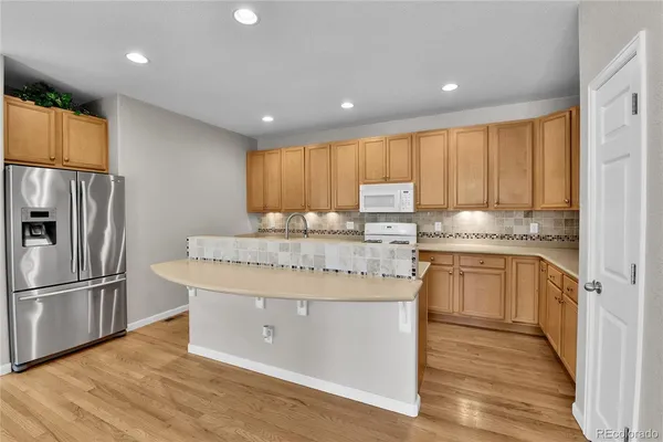 a kitchen with kitchen island granite countertop wooden cabinets and stainless steel appliances