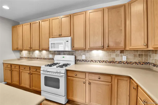 a kitchen with stainless steel appliances granite countertop a stove a sink and cabinets