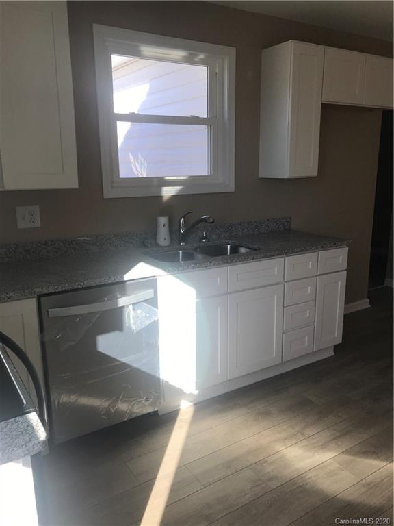 1507 Riley Street Albemarle, NC 28001 - Photo 16 of 26 a kitchen with stainless steel appliances a sink a stove and white cabinets