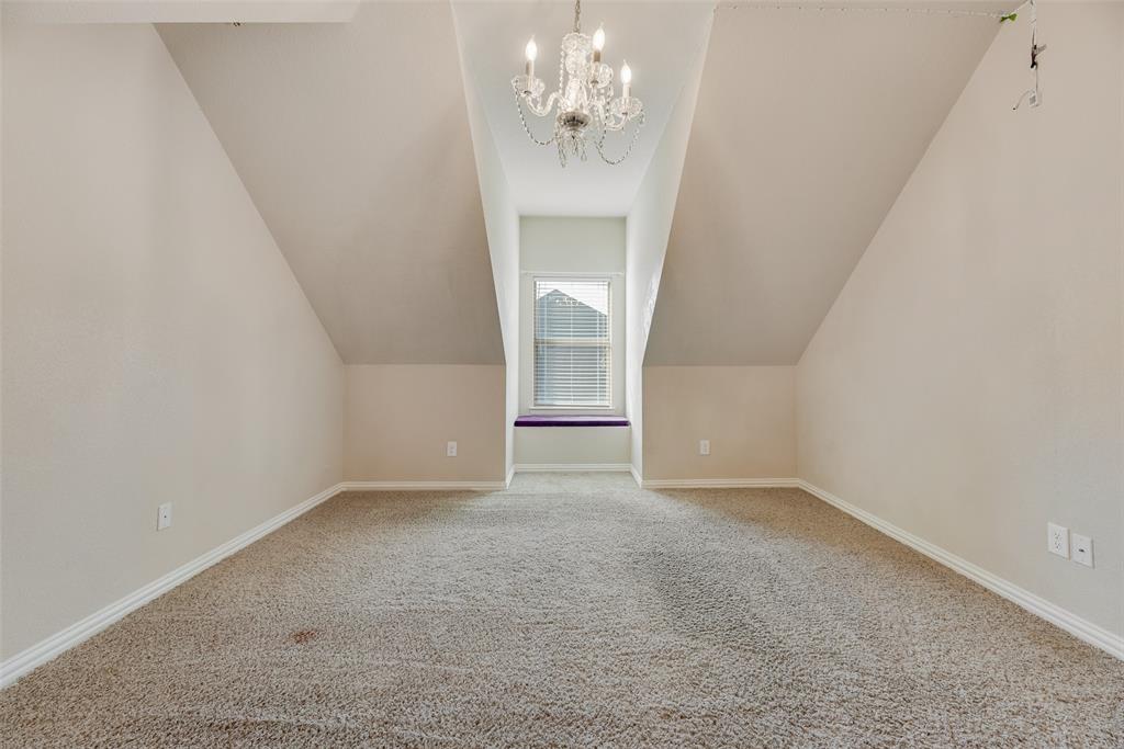 1010 Newington Circle Forney, TX 75126 - Photo 17 of 26 an empty room with a chandelier fan and windows