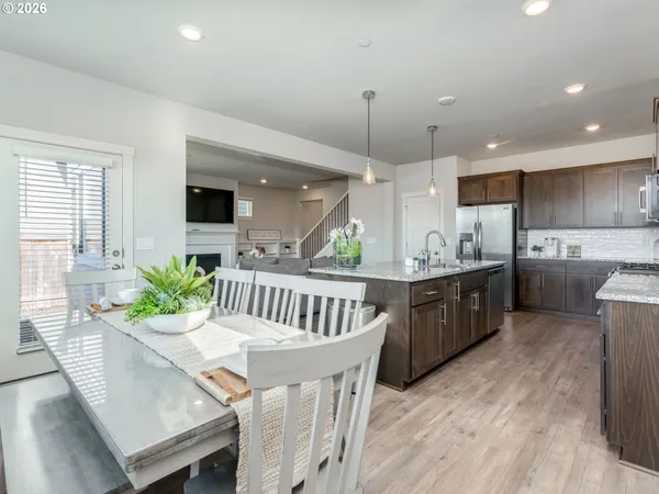 a kitchen with a table chairs sink microwave and cabinets