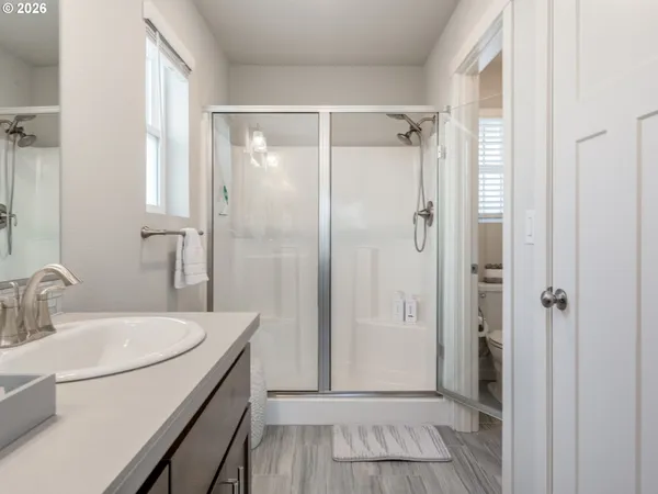 a bedroom with a bed and two windows