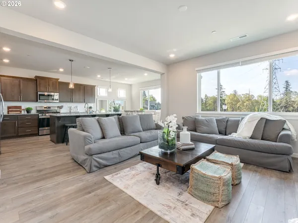 a living room with furniture kitchen and a large window