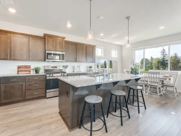 a kitchen with kitchen island granite countertop wooden floors and white cabinets