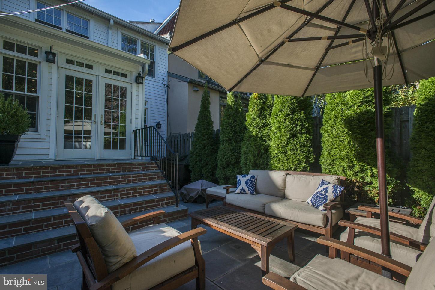 3813 T Street Northwest Washington, DC 20007 - Photo 20 of 24 a view of a patio with couches table and chairs under an umbrella