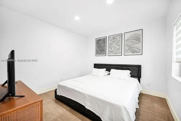 a bedroom with a bed and a flat screen tv