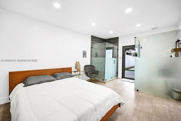 a bedroom with a bed and a large mirror