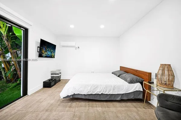 a bedroom with a bed and a flat screen tv