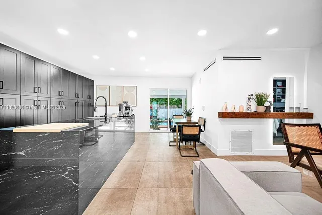 a living room with furniture and a dining table with kitchen view