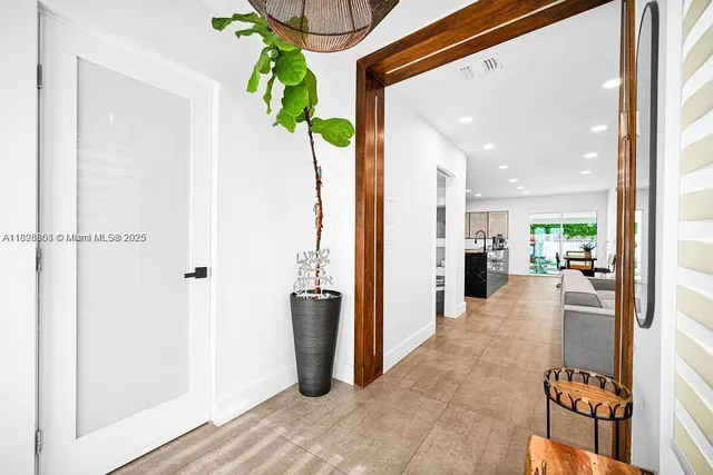 a view of a hallway with dining table and chairs