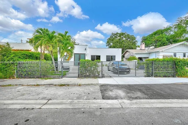 a view of a house with a yard and potted plants
