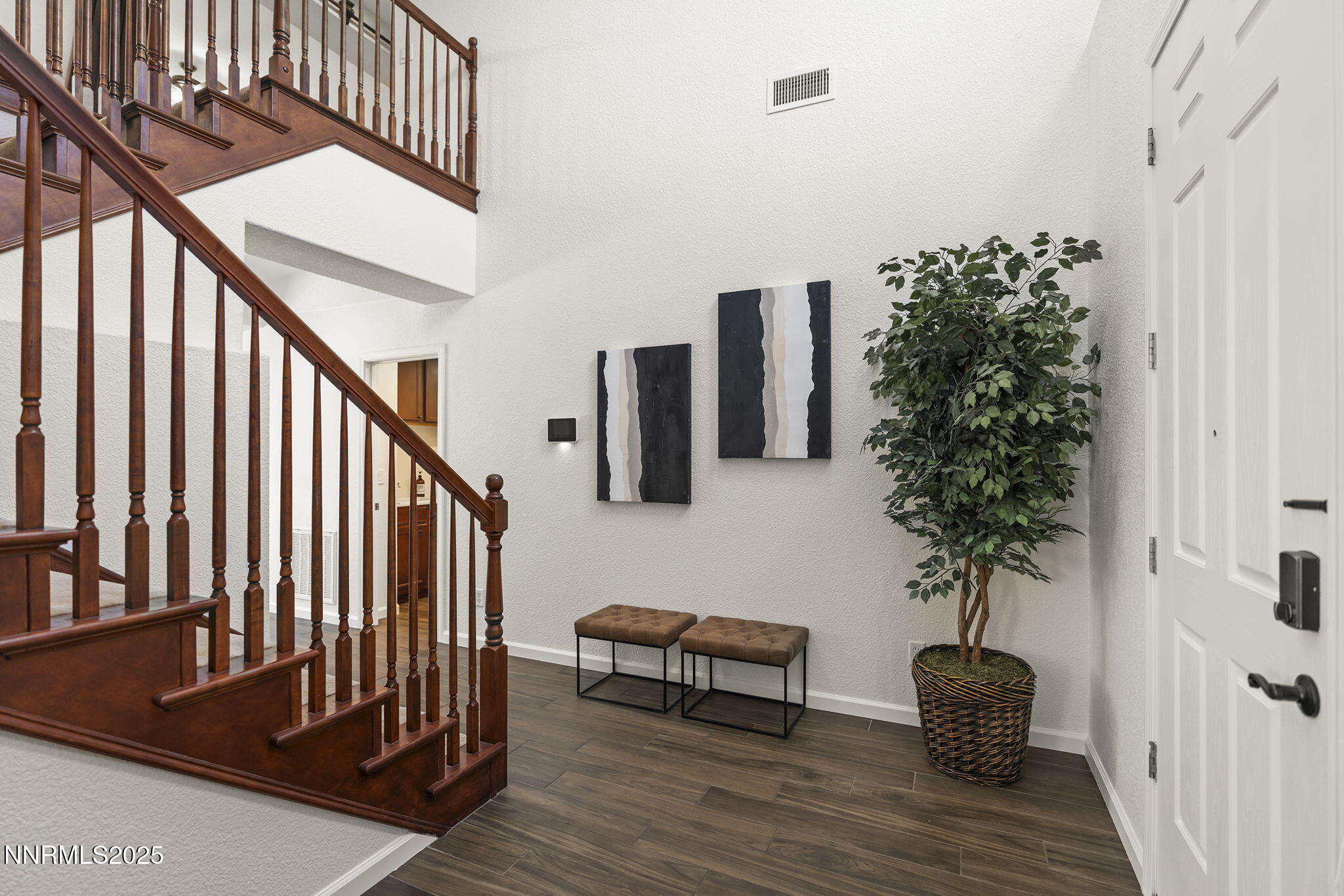 11135 Messina Way Reno, NV 89521 - Photo 3 of 31 a hallway with wooden floor stairs and a potted plant