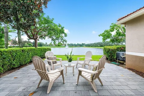 a view of a chairs and table in patio with a lake view