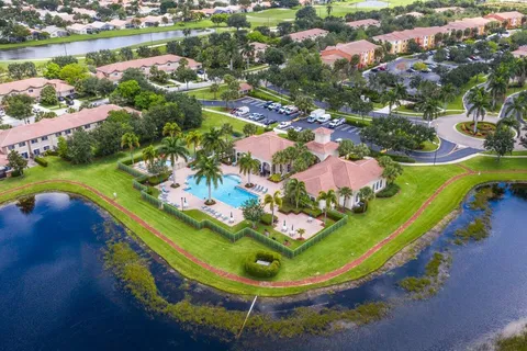 an aerial view of a house with a swimming pool yard and lake view in back