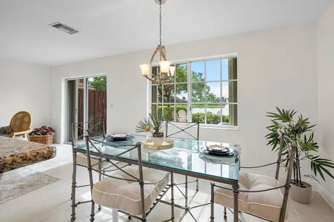 a dining room with furniture a chandelier and window