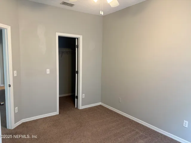 an empty room with closet and a bathroom