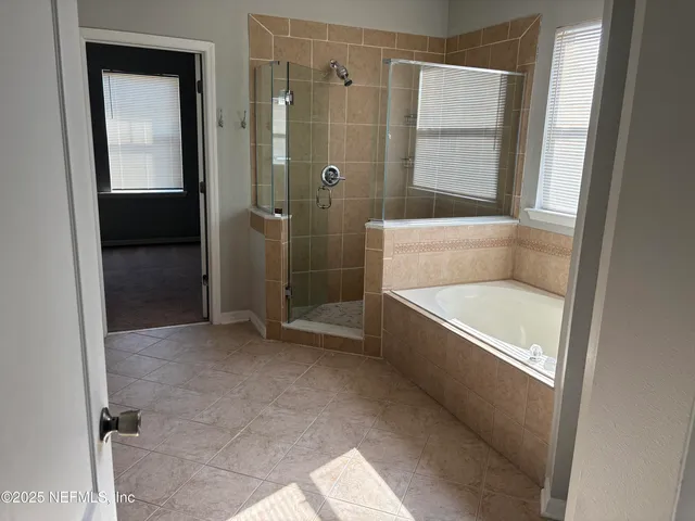 a bathroom with a tub shower and sink