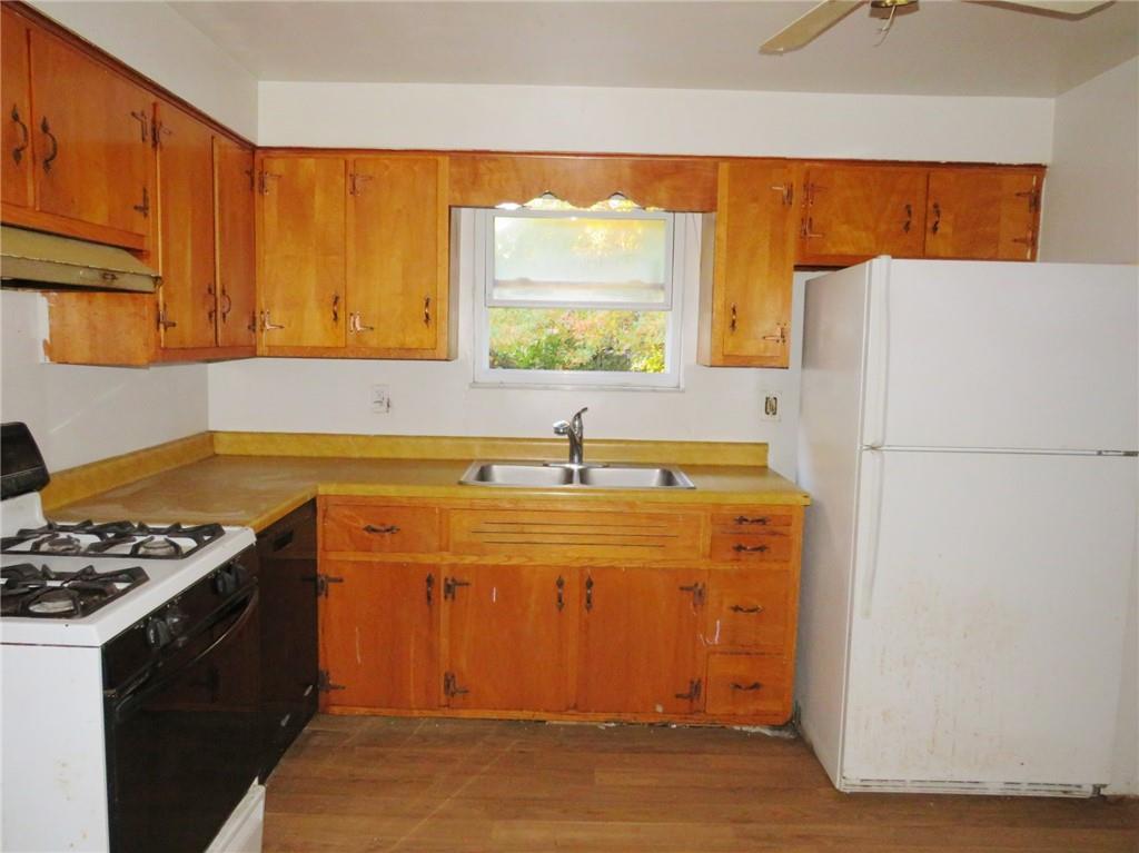 214 Erwin Place McKees Rocks, PA 15136 - Photo 22 of 25 a kitchen with stainless steel appliances a stove a refrigerator and a sink with wooden floors