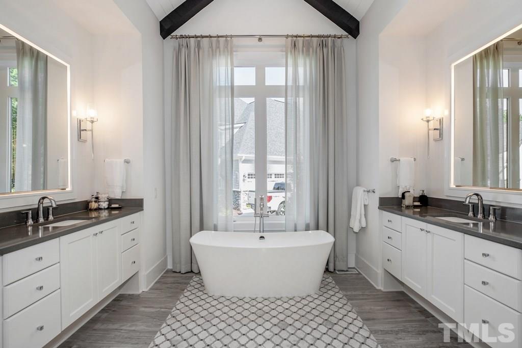 405 Vernon Terrace Raleigh, NC 27609 - Photo 12 of 26 a spacious bathroom with a double vanity sink a mirror and a bathtub