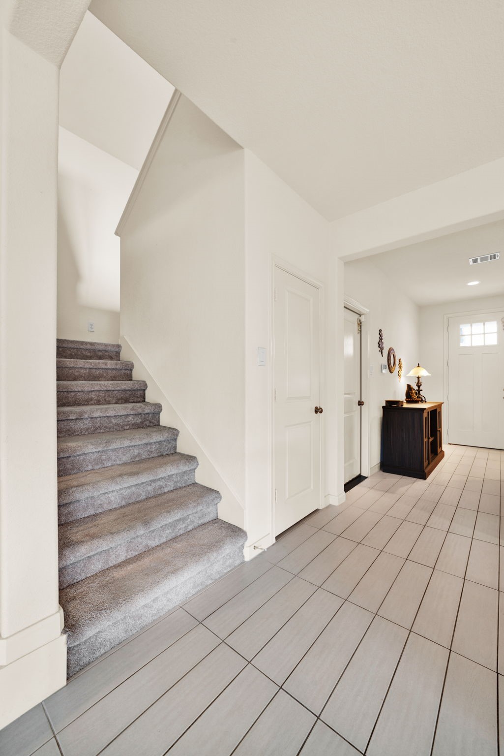 2503 Hagerman Road Conroe, TX 77384 - Photo 16 of 43 This entryway features a modern, tiled floor leading to a carpeted staircase.
