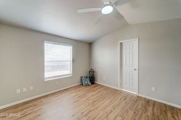 an empty room with wooden floor and windows