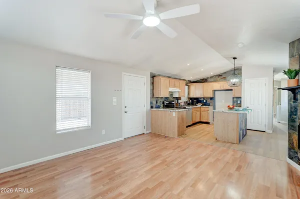 a room with kitchen island stainless steel appliances sink refrigerator and window