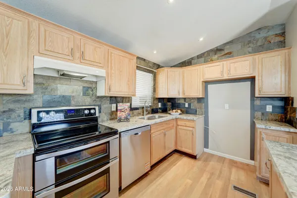 a kitchen with sink a microwave and cabinets