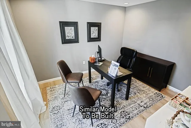 a view of a workspace room with wooden floor and lounge chair
