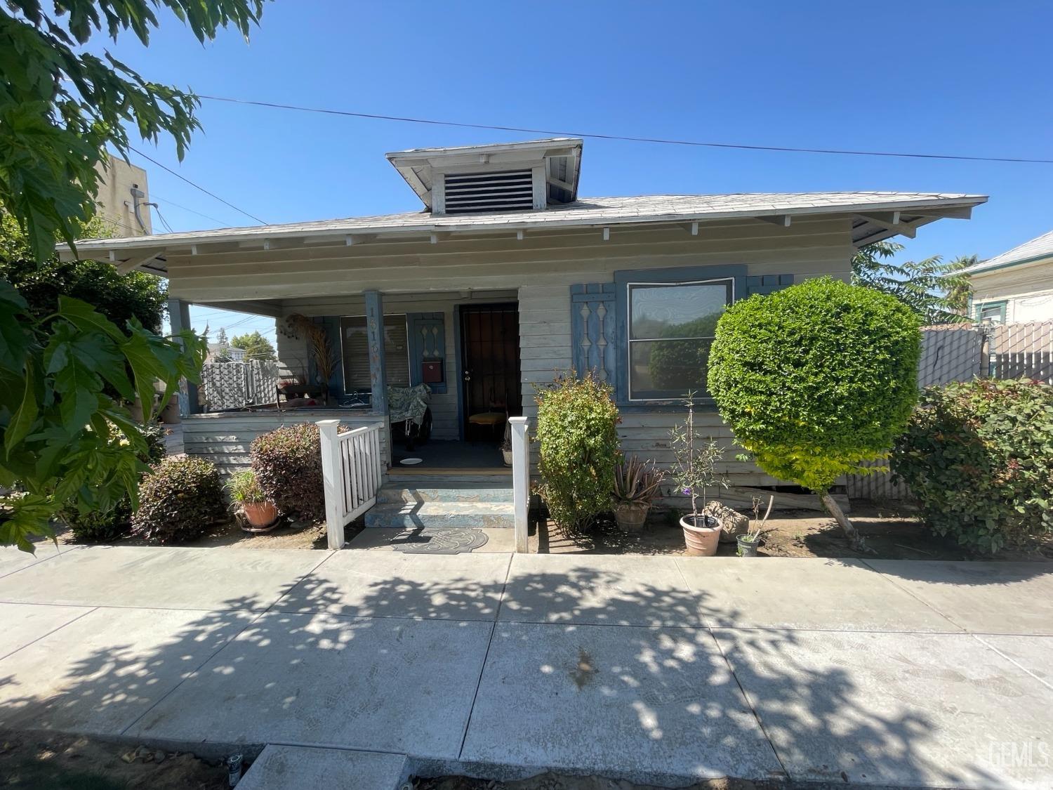 Undisclosed Address Bakersfield, CA 93304 - Photo 1 of 21 a view of a house with potted plants and a large tree