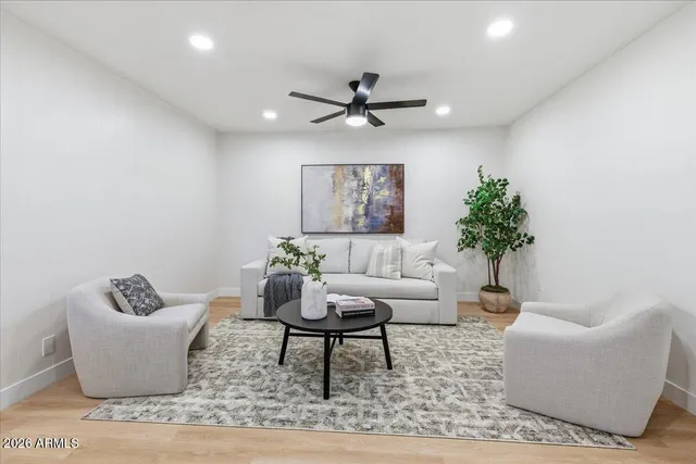 a view of a hallway with wooden floor a bathroom and a sink