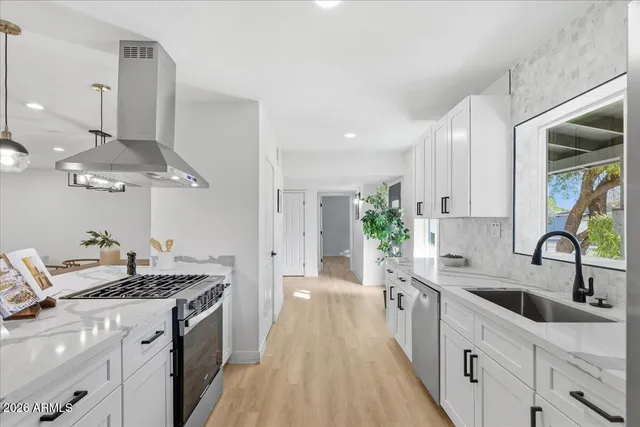 a kitchen with a sink dishwasher a stove top oven a counter space and cabinets