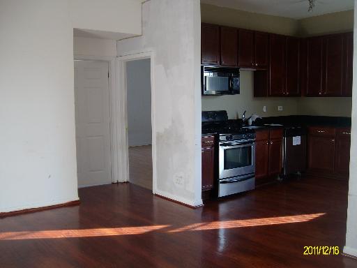5203 South Calumet Avenue, Unit 3D Chicago, IL 60615 - Photo 3 of 8 a kitchen with stainless steel appliances granite countertop a stove a microwave and a refrigerator