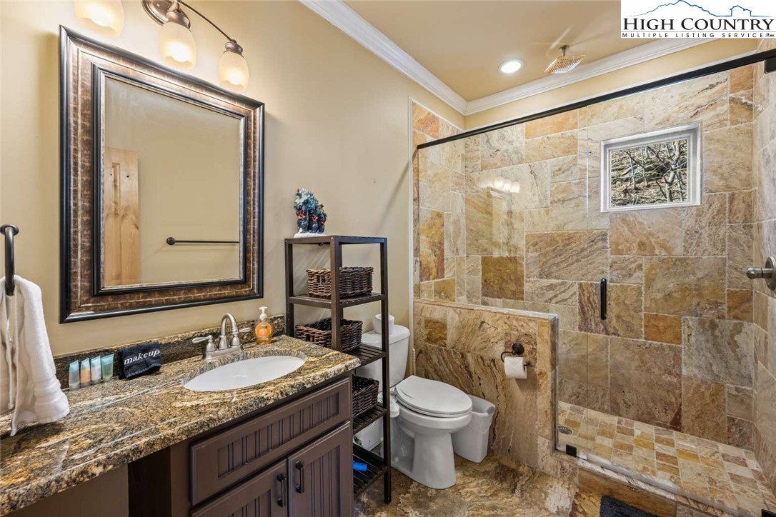 585 Stony Fork Road West Jefferson, NC 28694 - Photo 18 of 25 a bathroom with a granite countertop sink toilet and shower
