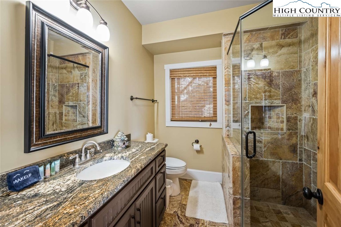 585 Stony Fork Road West Jefferson, NC 28694 - Photo 6 of 25 a bathroom with a granite countertop sink toilet and shower