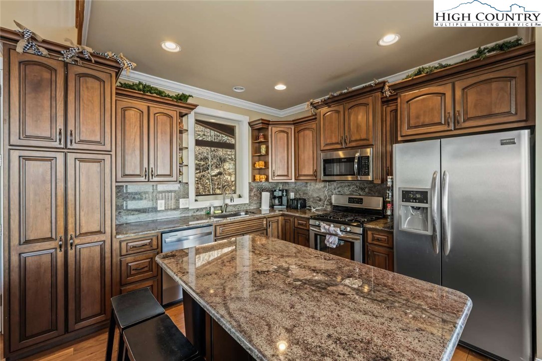585 Stony Fork Road West Jefferson, NC 28694 - Photo 8 of 25 a kitchen with stainless steel appliances granite countertop a refrigerator a stove top oven a sink and dishwasher