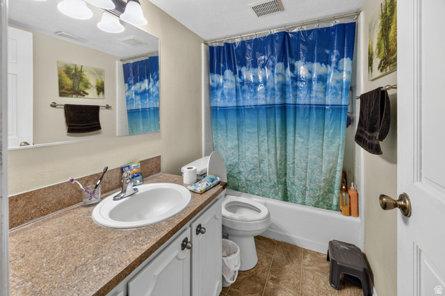 1218 East 100 South Logan, UT 84321 - Photo 17 of 23 Full bathroom featuring a white tub/shower combination, a toilet, a vanity with a laminate countertop, and a built-in sink