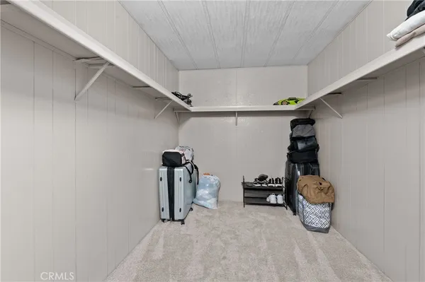 a walk in closet with wooden floor