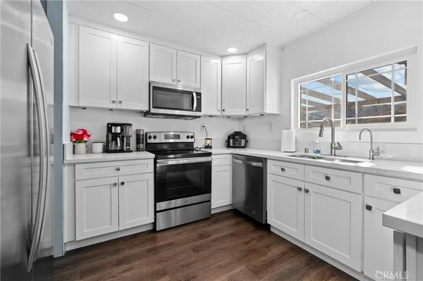 a kitchen with white cabinets and white appliances