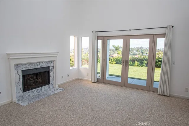 a view of an empty room with a fireplace and a window