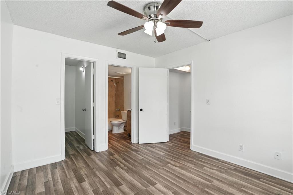 201-5 Santa Clara Drive, Unit 201 Naples, FL 34104 - Photo 11 of 23 an empty room with wooden floor a ceiling fan and closet