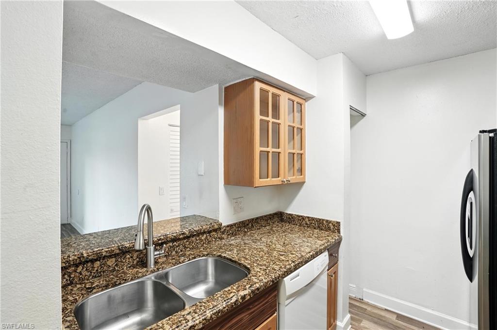 201-5 Santa Clara Drive, Unit 201 Naples, FL 34104 - Photo 13 of 23 a kitchen with stainless steel appliances granite countertop a sink and a refrigerator