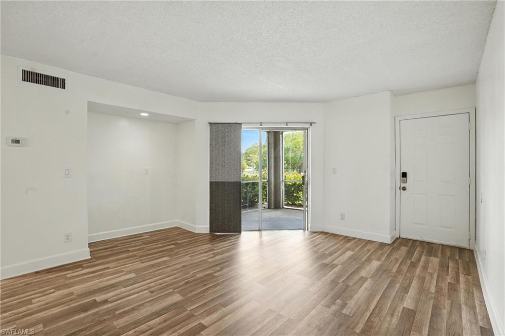 201-5 Santa Clara Drive, Unit 201 Naples, FL 34104 - Photo 14 of 23 a view of an empty room with wooden floor and a window
