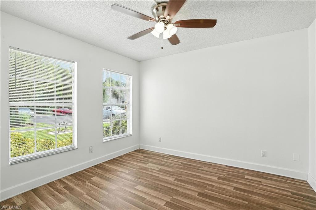 201-5 Santa Clara Drive, Unit 201 Naples, FL 34104 - Photo 17 of 23 wooden floor in an empty room with a window