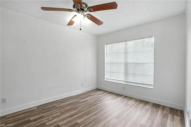 a view of a livingroom with wooden floor and a ceiling fan