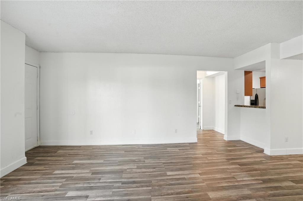 201-5 Santa Clara Drive, Unit 201 Naples, FL 34104 - Photo 8 of 23 a view of an empty room and wooden floor