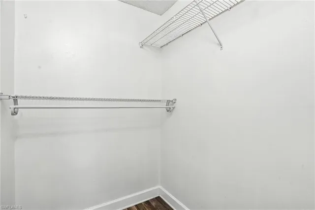 an empty room with wooden floor a ceiling fan and closet