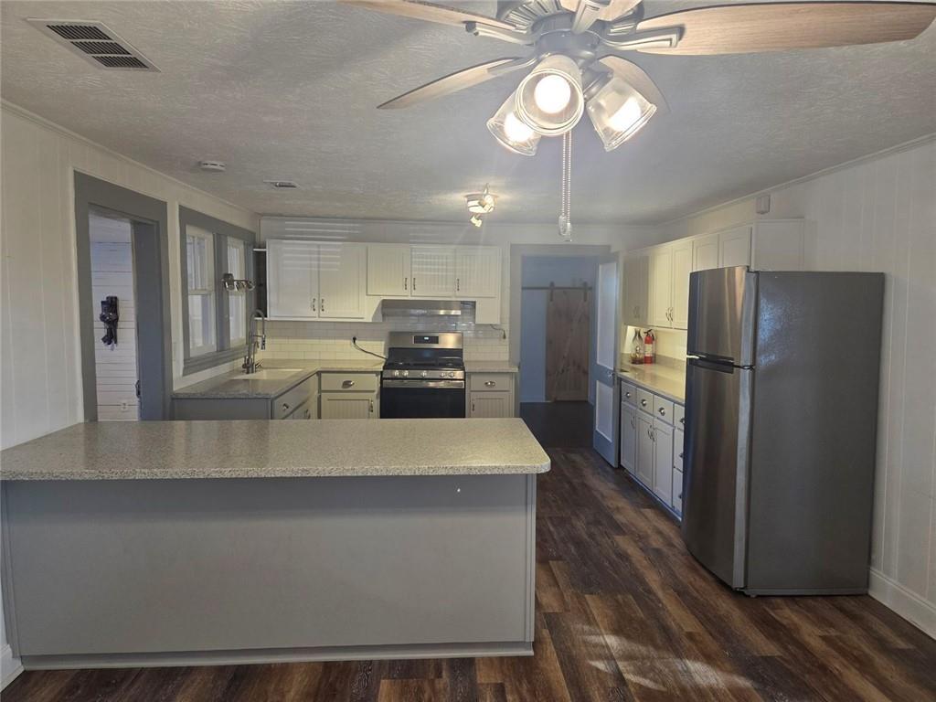 5465 Jot Em Down Road Cumming, GA 30041 - Photo 3 of 11 a kitchen with stainless steel appliances a refrigerator a stove top oven a sink and dishwasher