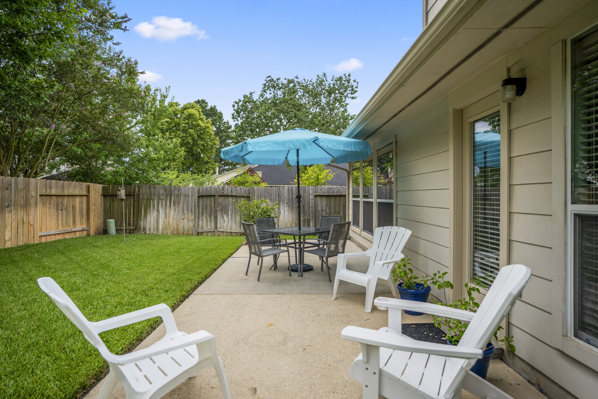 3411 Utah Beach Court Spring, TX 77388 - Photo 35 of 50 Patio living continues along the back of the home, with space already arranged for sitting, dining, and enjoying the backyard. The door connects back inside near the breakfast room and family room, making it easy to move between indoor gathering spaces and the outdoor patio, while the lawn extends out toward the fence for added breathing room.