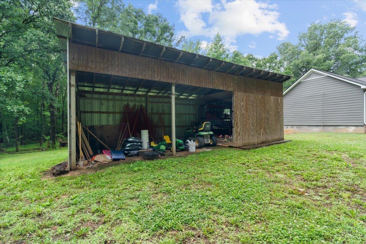150 Liberty Road Moscow, TN 38057 - Photo 28 of 36 Open-sided utility shed with a corrugated metal roof and wood paneling