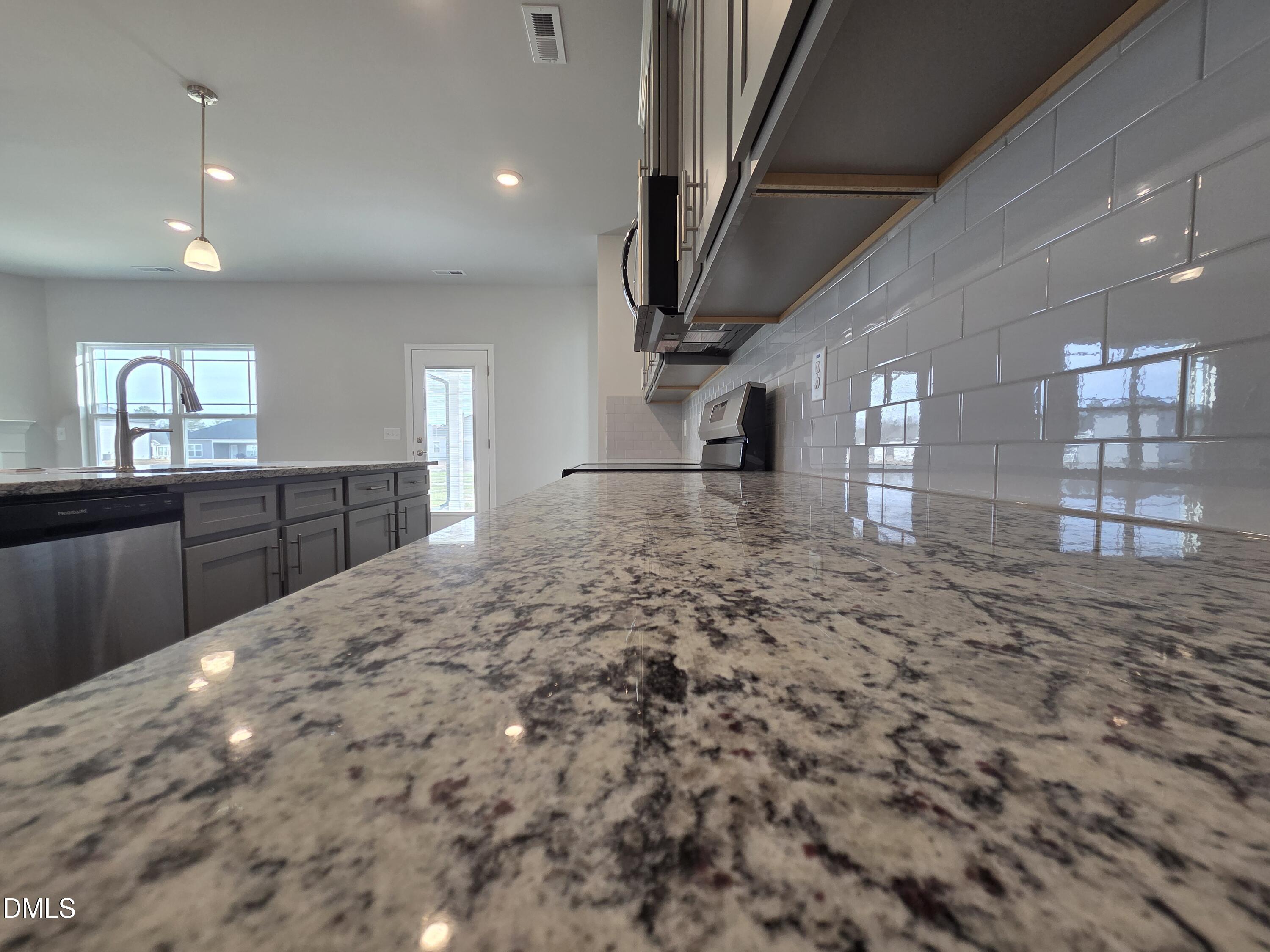 4979 Trident Maple Court Battleboro, NC 27809 - Photo 15 of 41 a large kitchen with kitchen island a sink stainless steel appliances and cabinets